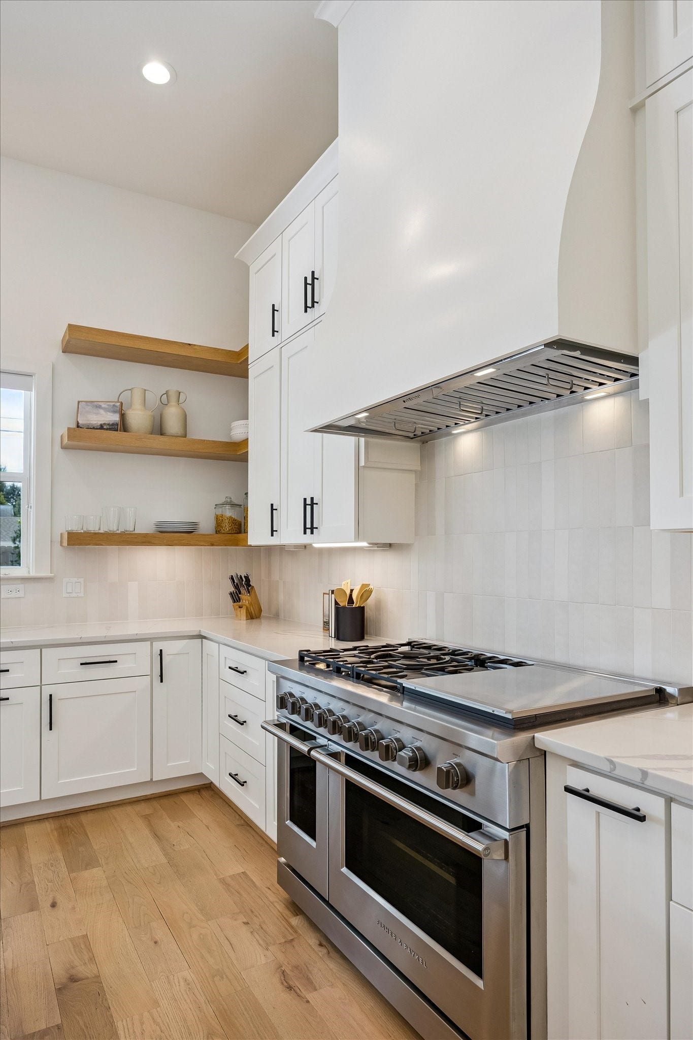 Custom floating shelves add a stylish, modern touch to the kitchen while providing the perfect space to display curated dcor, glassware and everyday essentials.