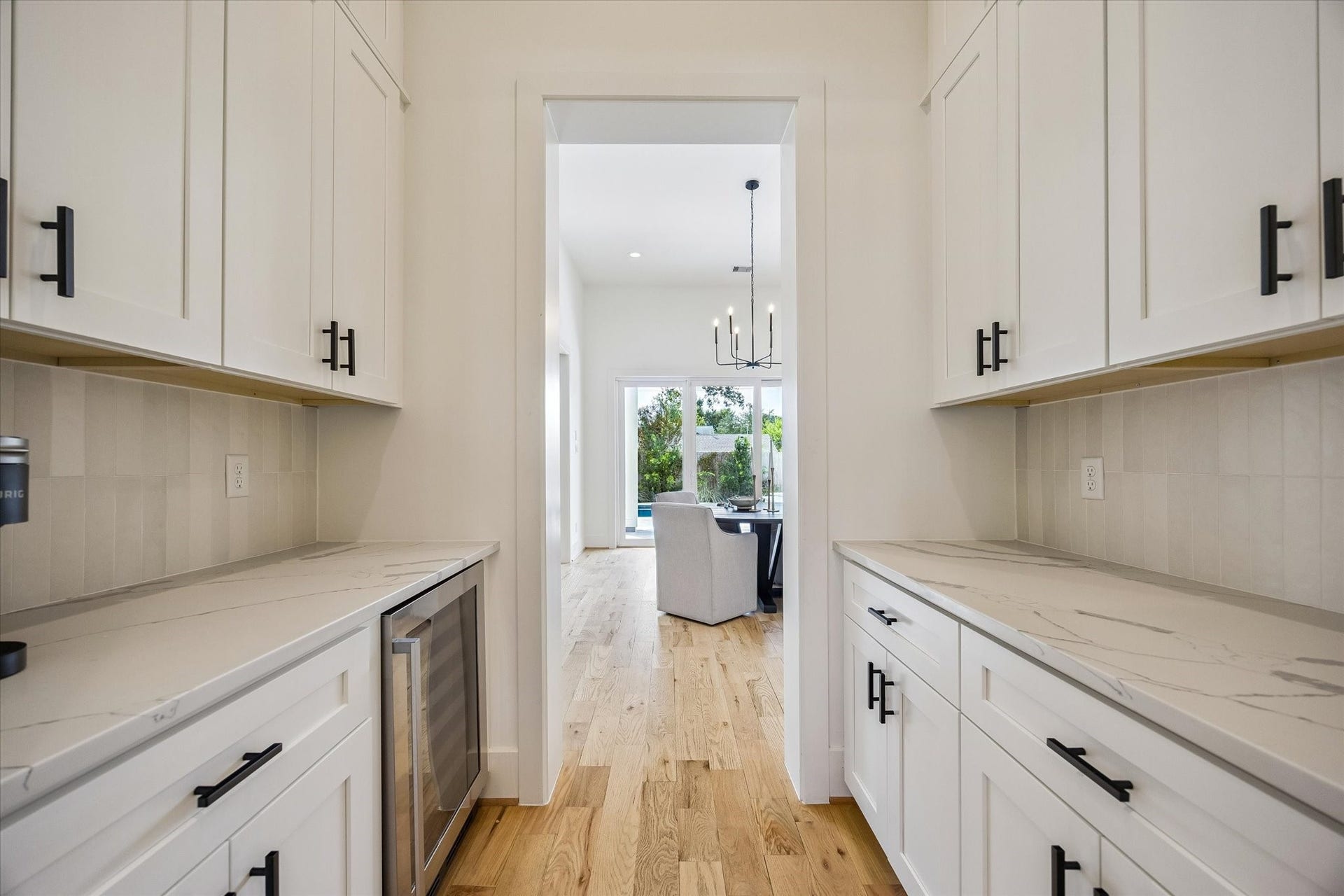 A stylish dry bar seamlessly connects the dining and kitchen areas, featuring a Hisense beverage refrigerator and offering the perfect space to prep drinks and entertain guests at your next gathering.