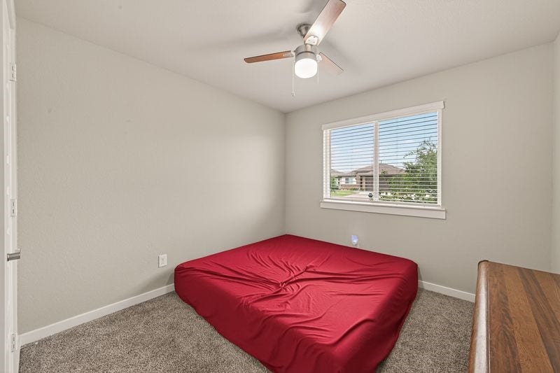 7523 Keystone Blossom Trail, Richmond, TX 77407 Secondary bedroom featuring soft carpet underfoot, a central ceiling fan, and a well-placed window inviting natural light into the space.