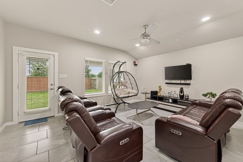 7523 Keystone Blossom Trail, Richmond, TX 77407 Alternate angle of the living area showcasing backyard access through a glass-paneled door, complemented by multiple windows that enhance brightness throughout the space.
