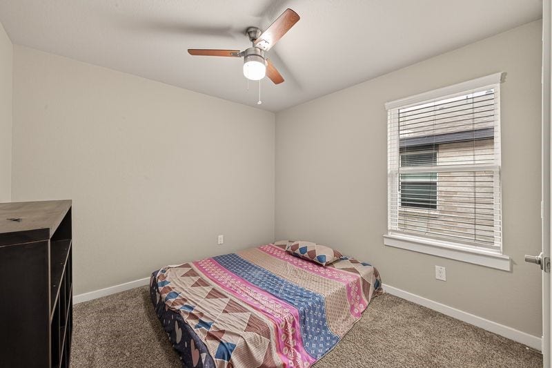 7523 Keystone Blossom Trail, Richmond, TX 77407 Additional bedroom offering plush carpeting, a ceiling fan overhead, and a window that brings in natural light while maintaining a simple, functional layout.