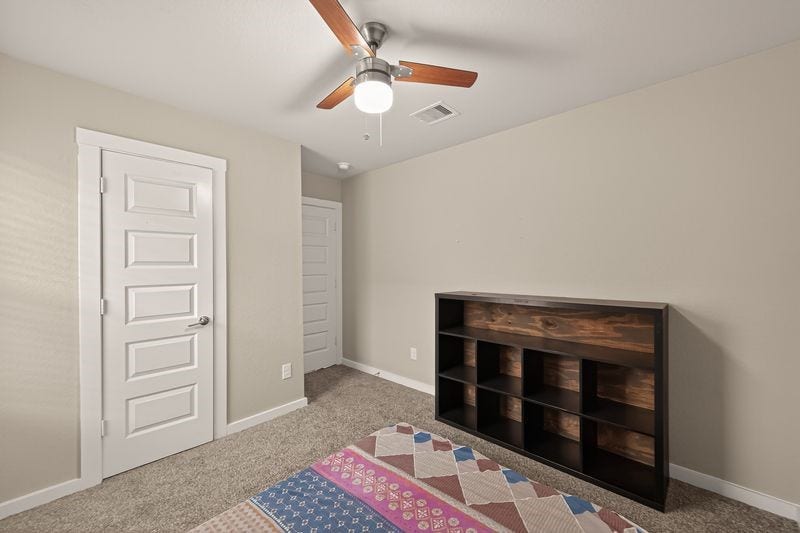 7523 Keystone Blossom Trail, Richmond, TX 77407 Same bedroom showcasing closet access, clean wall space, and a streamlined layout under a central ceiling fan.