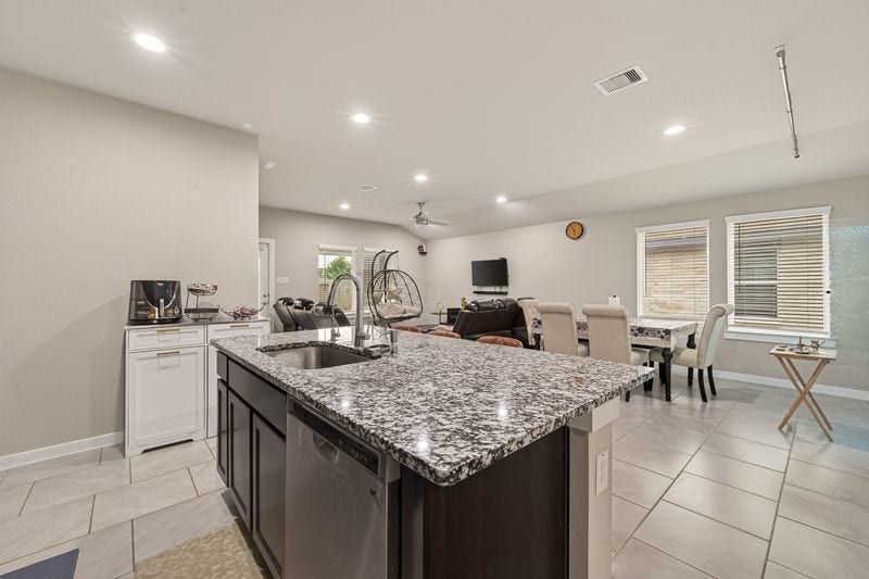 7523 Keystone Blossom Trail, Richmond, TX 77407 Reverse view from the kitchen island capturing the open connection to the dining and living areas, with expansive countertops and clear sightlines across the space.