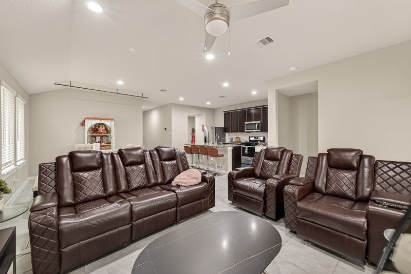 7523 Keystone Blossom Trail, Richmond, TX 77407 Another perspective of the living area oriented toward the kitchen, highlighting the open sightlines, bar seating, and integrated layout ideal for everyday living.