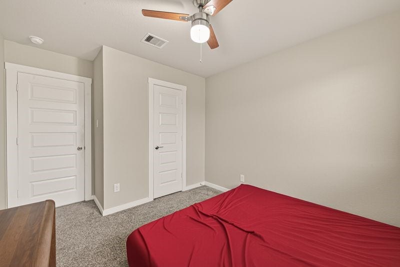 7523 Keystone Blossom Trail, Richmond, TX 77407 Alternate view of the bedroom highlighting the window placement and ceiling fan, with a clean layout and neutral tones throughout.