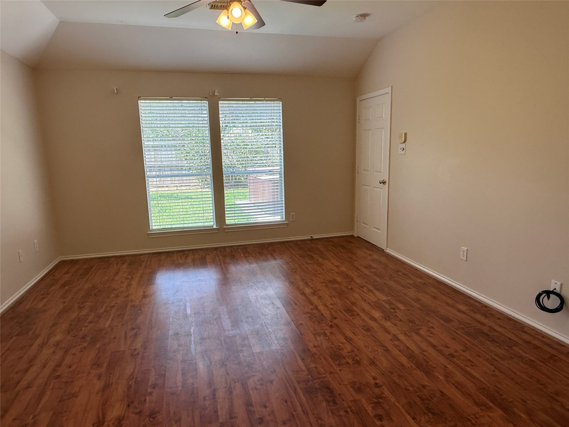 3511 Paigewood Drive, Pearland, TX 77584 Primary bedroom with rich luxury vinyl plank flooring, large windows for natural light, and a ceiling fan for comfort.