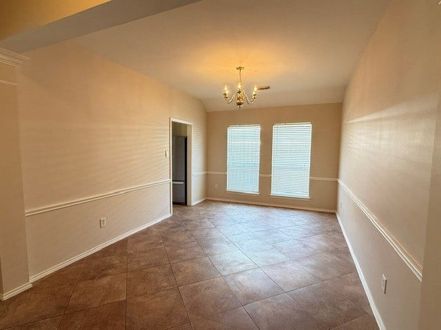 3511 Paigewood Drive, Pearland, TX 77584 Spacious dining area or could be open home office with elegant chandelier, large windows for natural light, and stylish tile flooring.