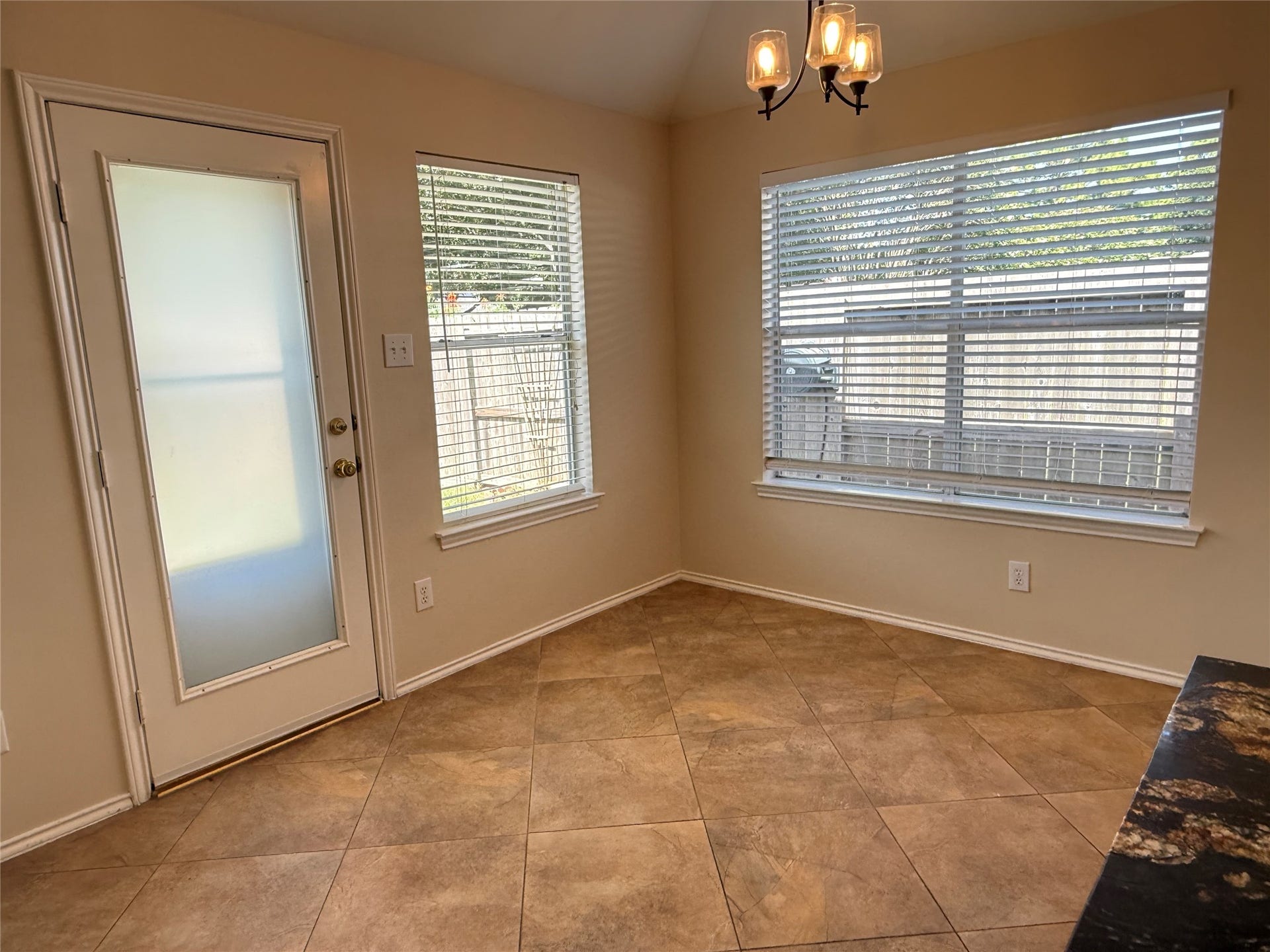 3511 Paigewood Drive, Pearland, TX 77584 Bright and inviting breakfast nook with tile flooring, large windows, and a door leading to the backyard, perfect for morning coffee.
