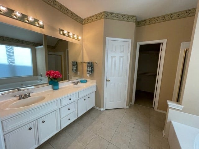 3511 Paigewood Drive, Pearland, TX 77584 Spacious bathroom featuring a double vanity with ample storage, elegant lighting, and a walk-in closet.