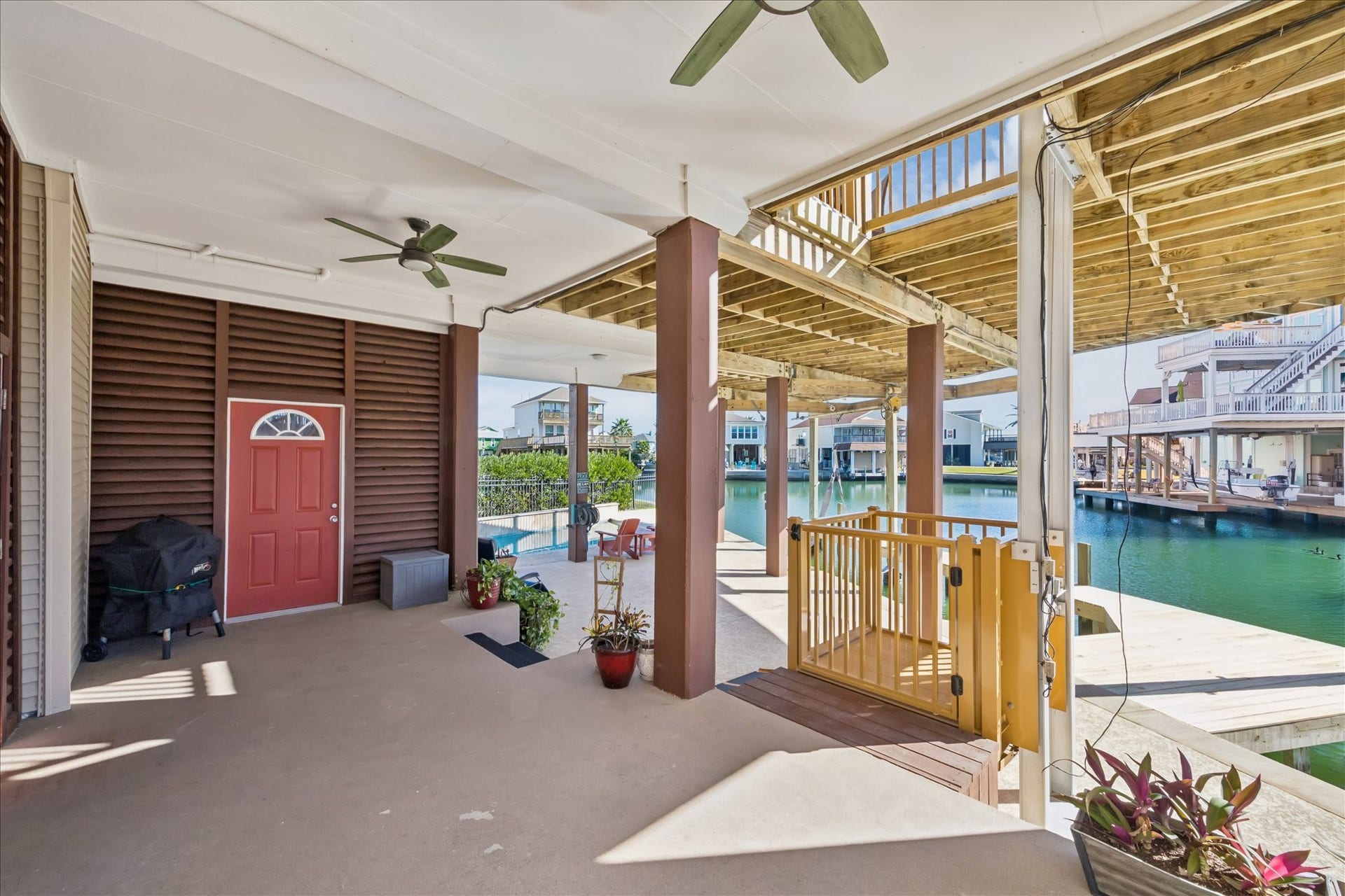107 Bamaku Bend, Tiki Island, TX 77554 Two levels of outdoor space provides generous overhead shade and multiple options to spread out just steps from the water. A conveniently located refrigerator keeps drinks and refreshments close at hand.