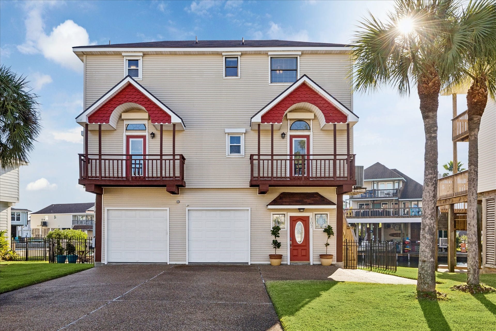 107 Bamaku Bend, Tiki Island, TX 77554 Two private balconies bring the living space outdoors, offering separate places to enjoy the island air. Spacious driveway plus additional parking nook accommodate up to 10 vehicles. Two colorful stained-glass windows greet you at the front entry.