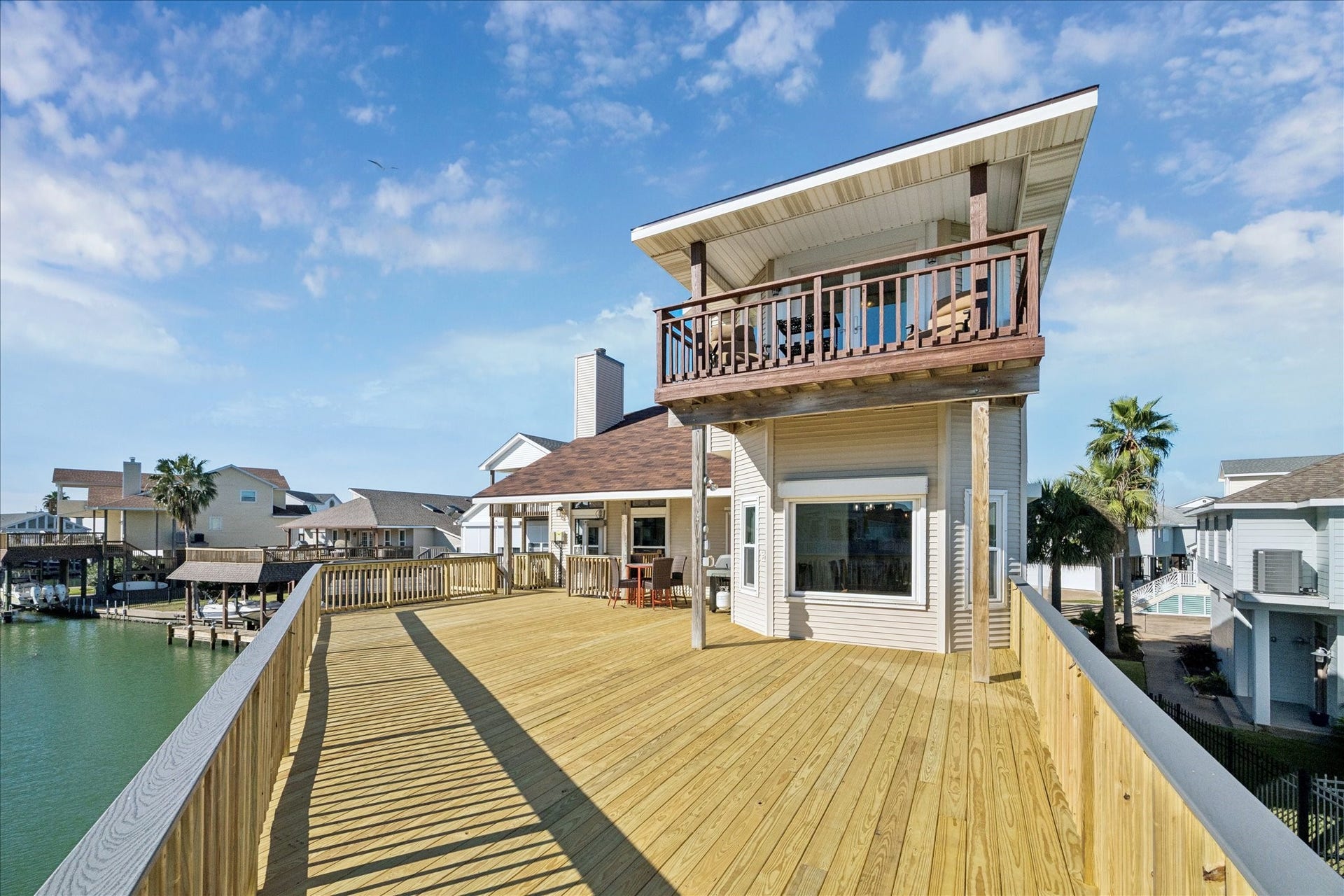 107 Bamaku Bend, Tiki Island, TX 77554 The primary suite's balcony creates a personal retreat, set apart from the home's expansive main deck below.
