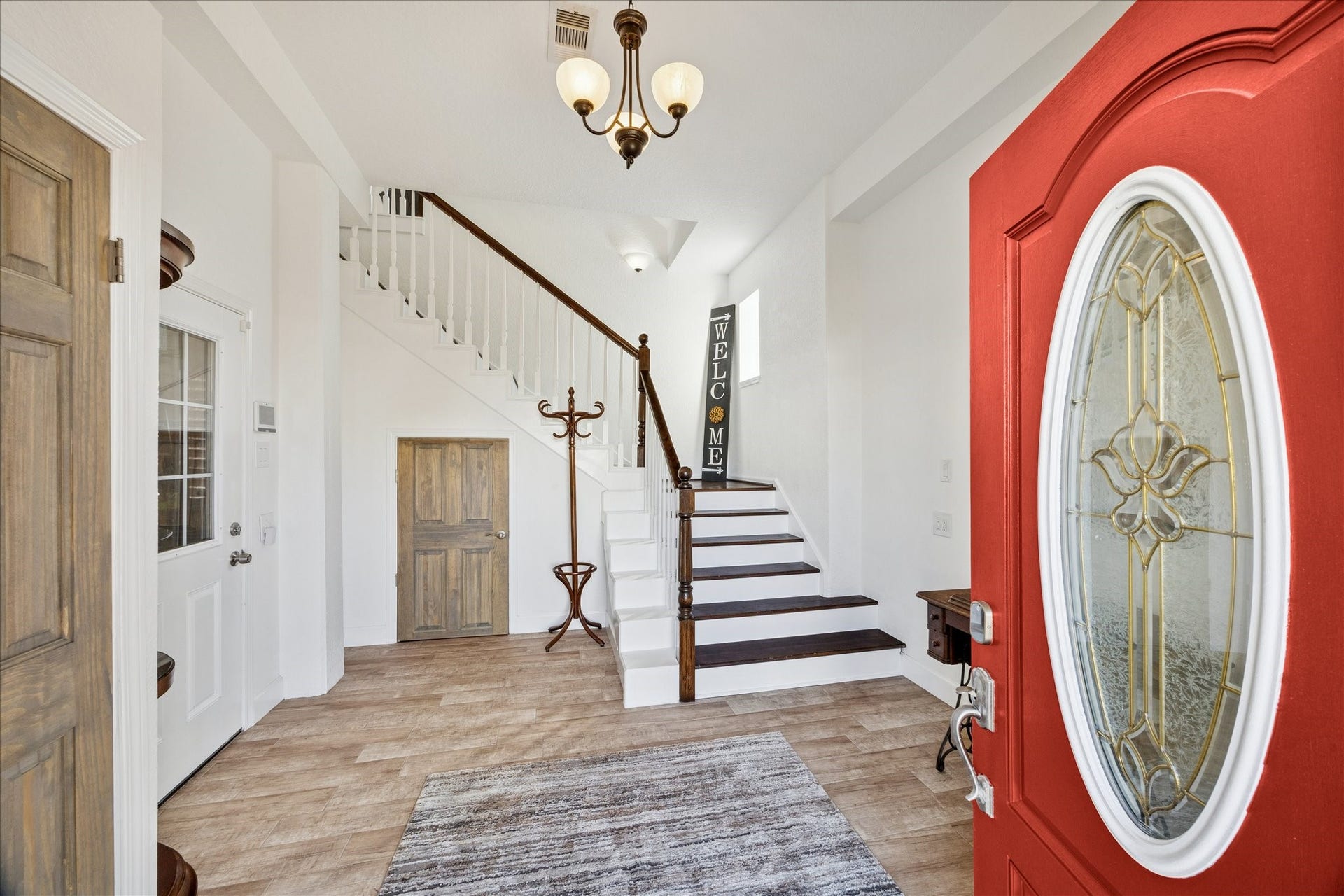 107 Bamaku Bend, Tiki Island, TX 77554 Ground-floor entry welcomes you with natural light and distinctive style. Solid stained wood doors throughout add warmth, while the wide staircase leads to the home's upper living spaces.