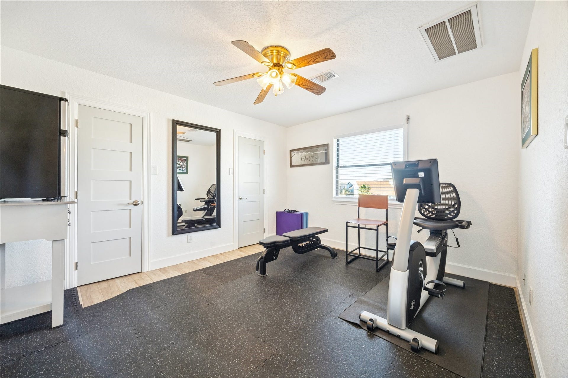 107 Bamaku Bend, Tiki Island, TX 77554 Currently configured as a workout room, this second-floor bedroom can easily return to its intended use. An ensuite bath and two closets with wall-to-wall storage add everyday function.
