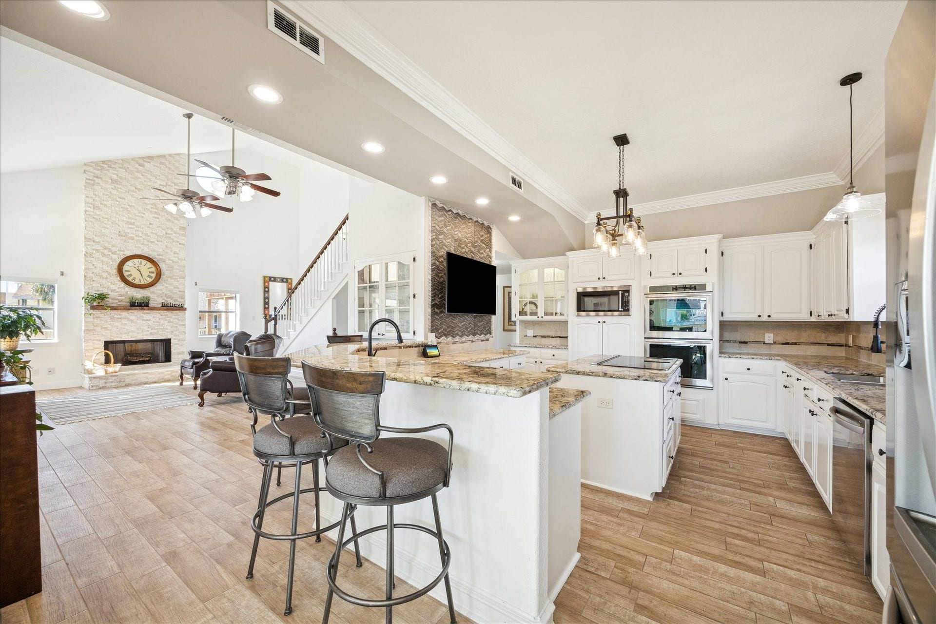 107 Bamaku Bend, Tiki Island, TX 77554 Open to the family room, the kitchen keeps everyone connected, whether cooking, gathering around the bar, or entertaining friends and family.