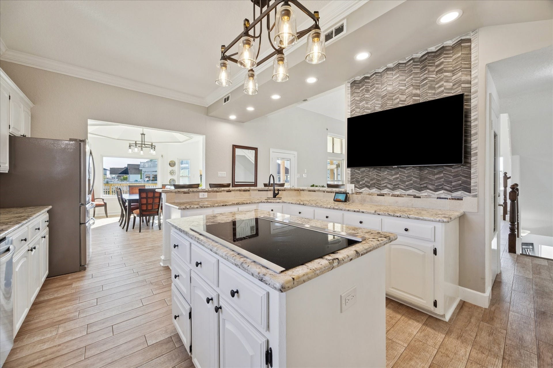 107 Bamaku Bend, Tiki Island, TX 77554 A wraparound bar seats six, while the pull-and-swivel TV adds a fun touch for game day. Point the TV toward the dining area when the conversations move to the dining table.