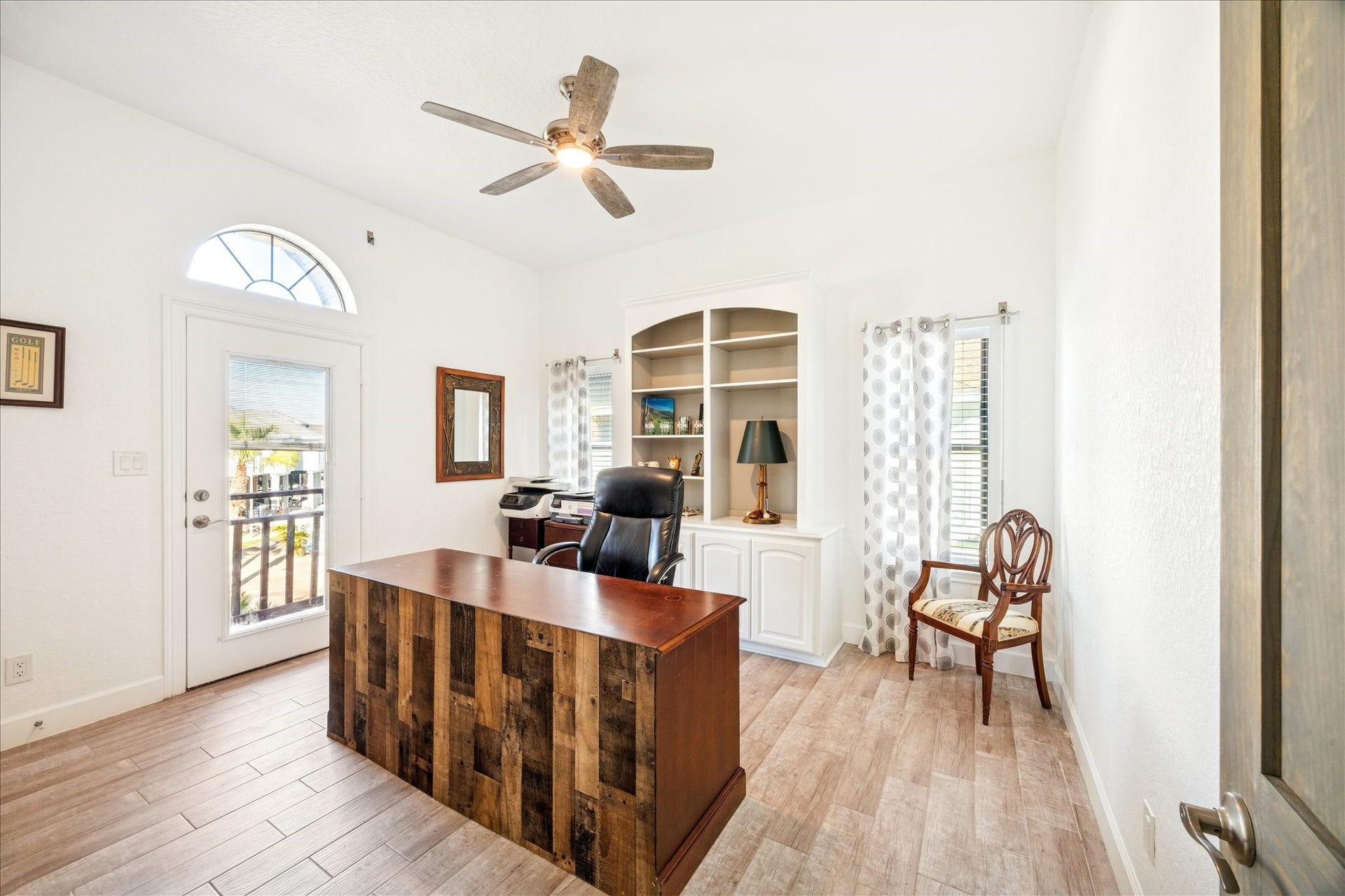 107 Bamaku Bend, Tiki Island, TX 77554 A view toward the canal and built-in millwork with display shelving and cabinets enhance this flexible bedroom or office. A double-door closet adds storage, while a private balcony gives the room its own outdoor escape.