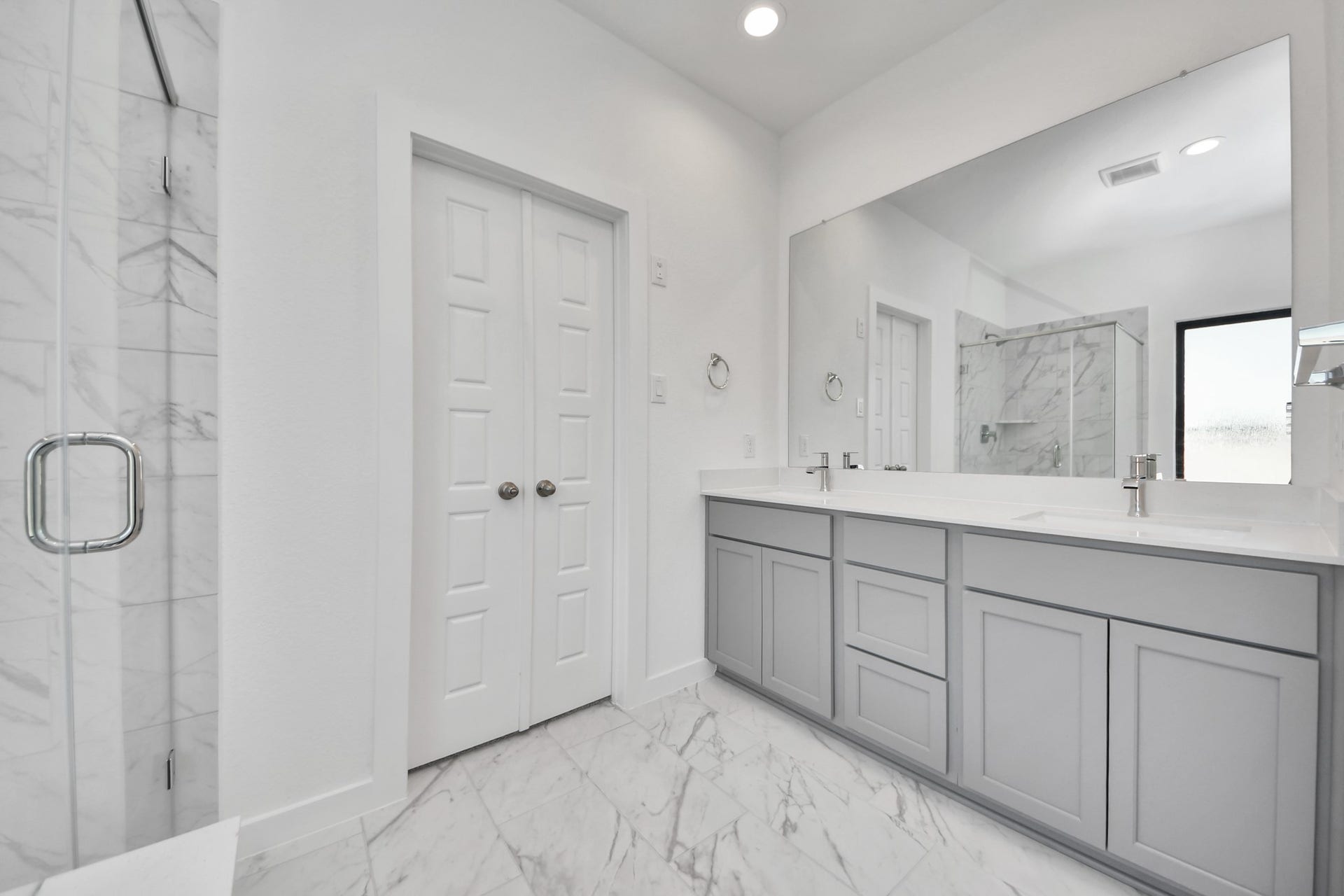 Elevate your daily routine at the elegant vanity, now equipped with double sinks, light countertops, modern hardware, and beautiful recessed lights. Sample photo of completed home with similar floor plan. Actual colors and selections may vary.