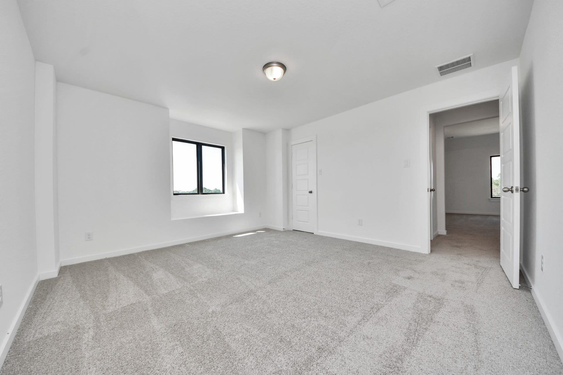 Secondary bedroom features plush carpeting, large windows that let in plenty of natural light, bright paint, and spacious closets. Sample photo of completed home with similar floor plan. Actual colors and selections may vary.