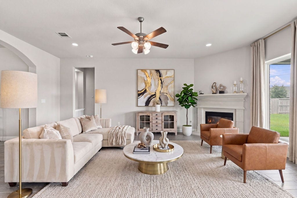 6914 Red Oak Drive, Katy, TX 77493 Elegant living room with a cozy fireplace, stylish furniture, and large windows offering abundant natural light.