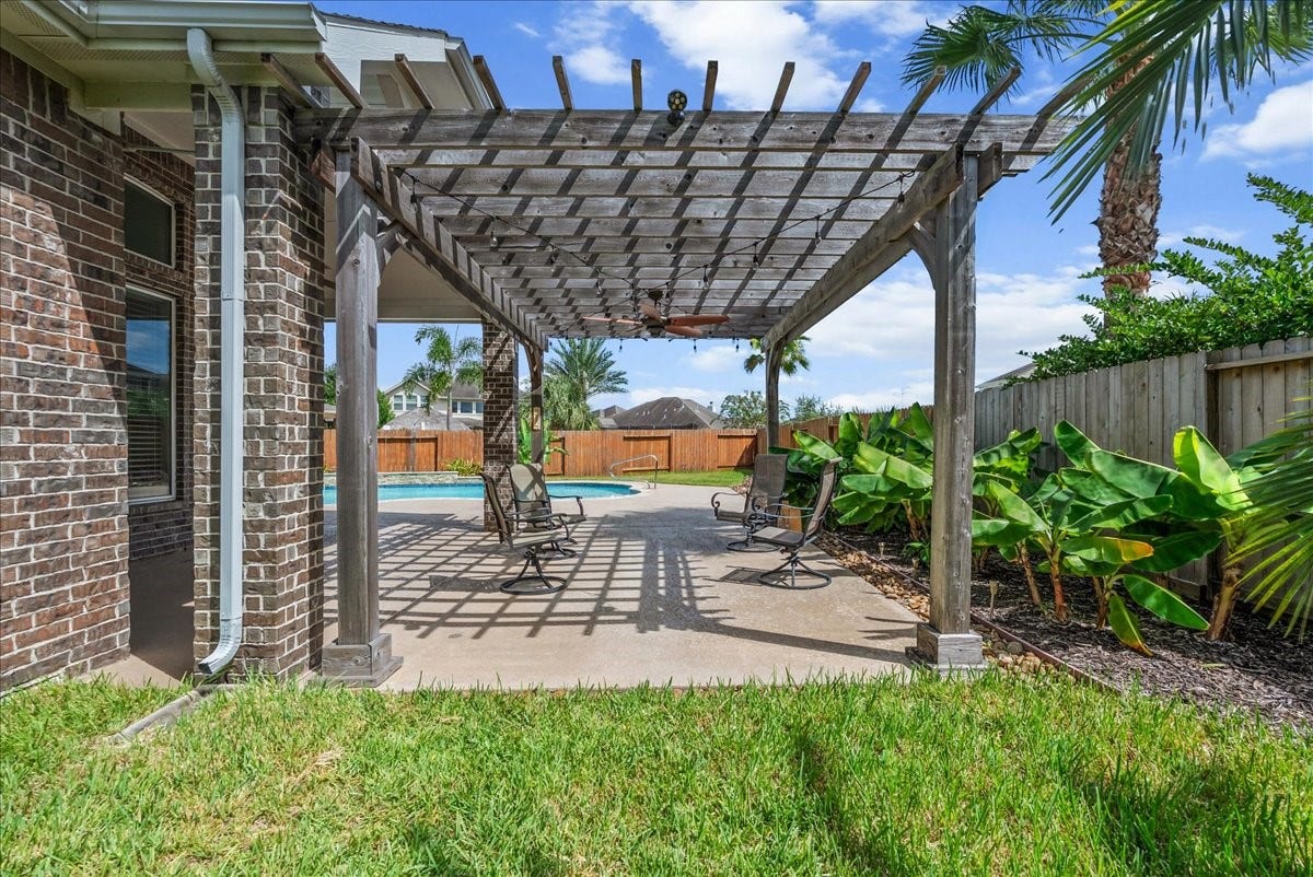 Charming backyard oasis featuring a spacious pergola, lush greenery, and a sparkling pool, perfect for relaxation and outdoor entertaining.