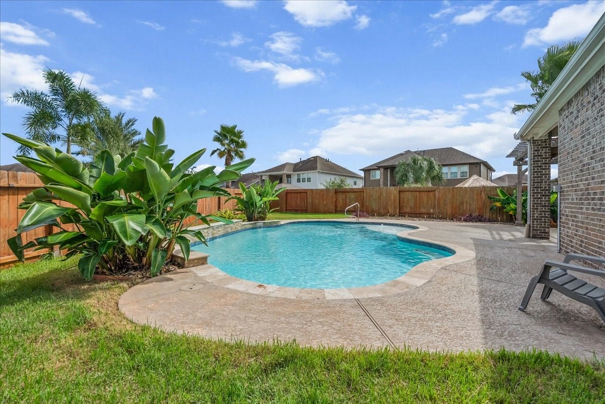Enjoy a private oasis with this beautifully landscaped backyard featuring a sparkling pool, surrounded by lush greenery and ample patio space for relaxation.  Plenty of room for an outdoor kitchen of your dreams.