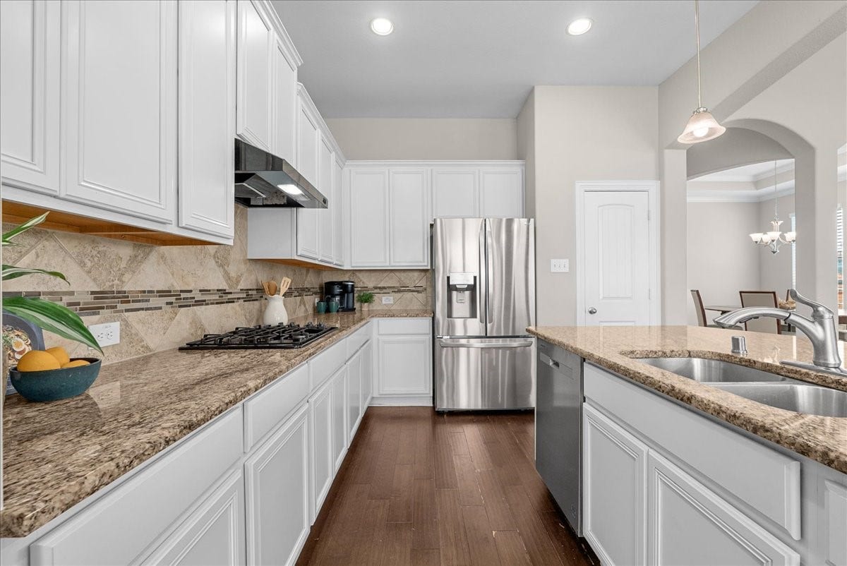 Sleek kitchen with granite countertops, stainless steel appliances, and white cabinetry, offering ample space and modern elegance.  Refrigerator does not convey with the sale of the home.