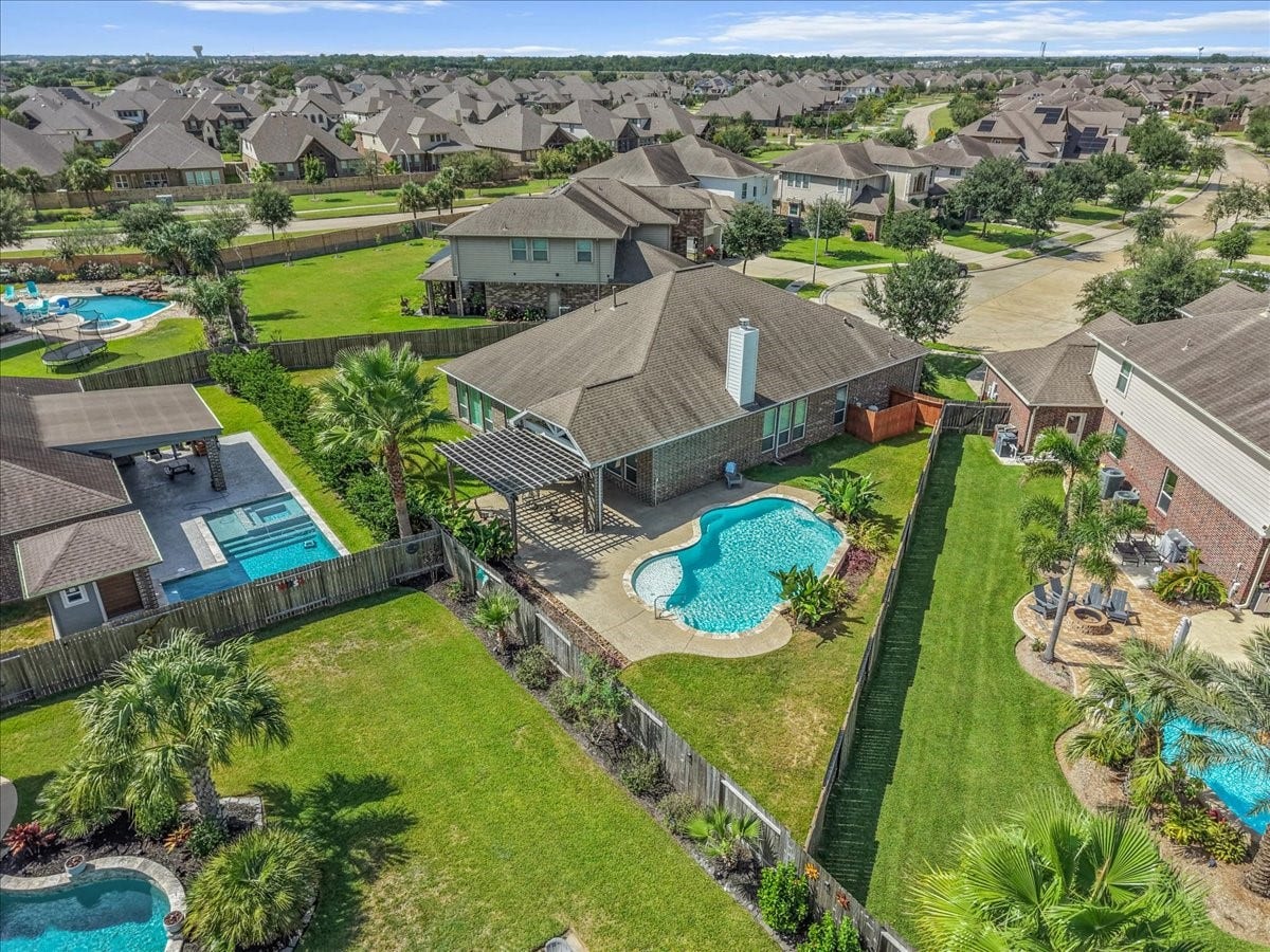 Expansive backyard oasis featuring a sparkling pool, lush landscaping, and a covered patio perfect for outdoor entertaining, nestled in a picturesque neighborhood.  A perfect spot in Mar Bella!  Come check it out!