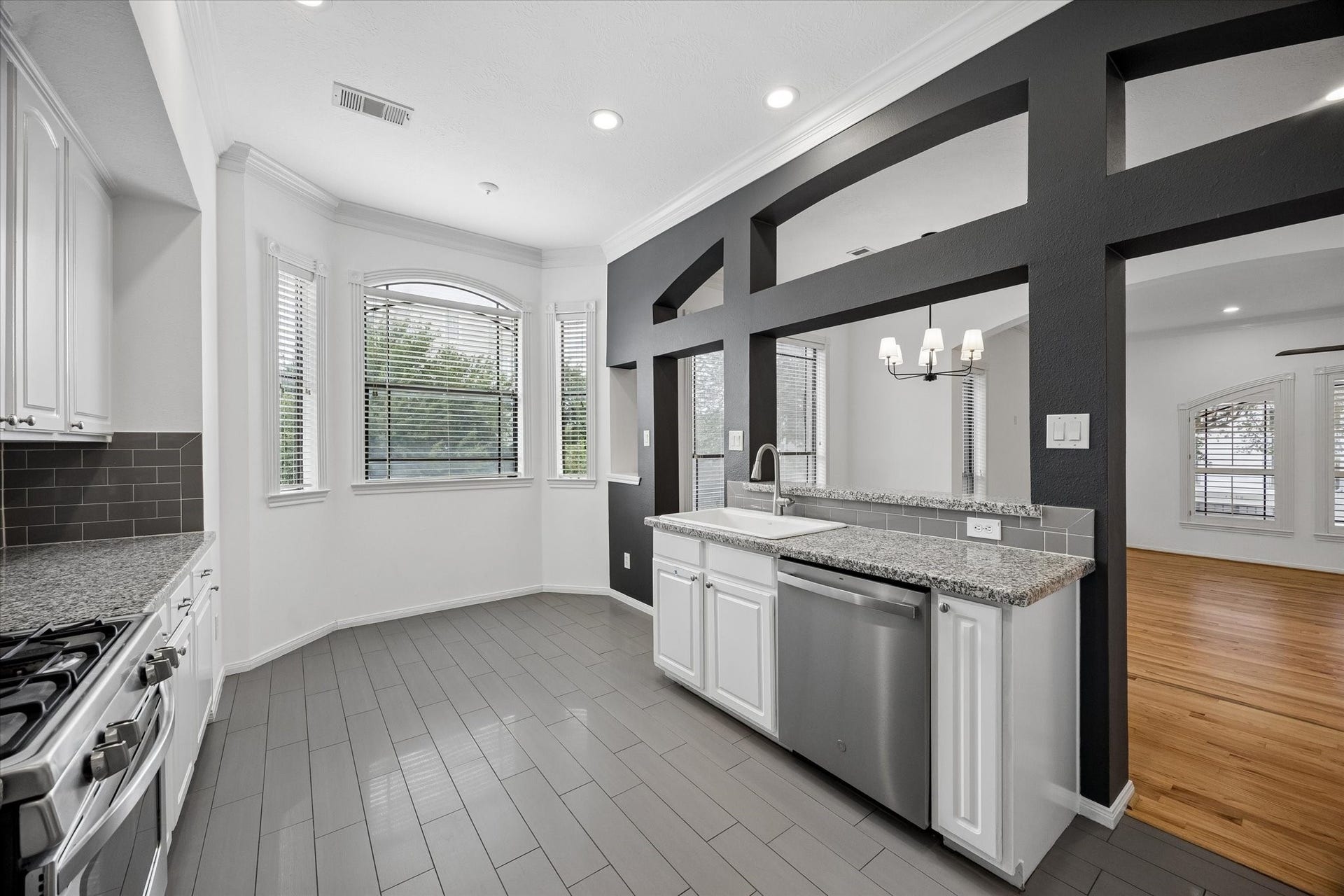 4123 Mcduffie Street, Houston, TX 77098 Modern, grey and white kitchen with granite counters and grey tile backsplash and floor complete the contemporary sleek look. Nook space at end for a small desk or breakfast table.