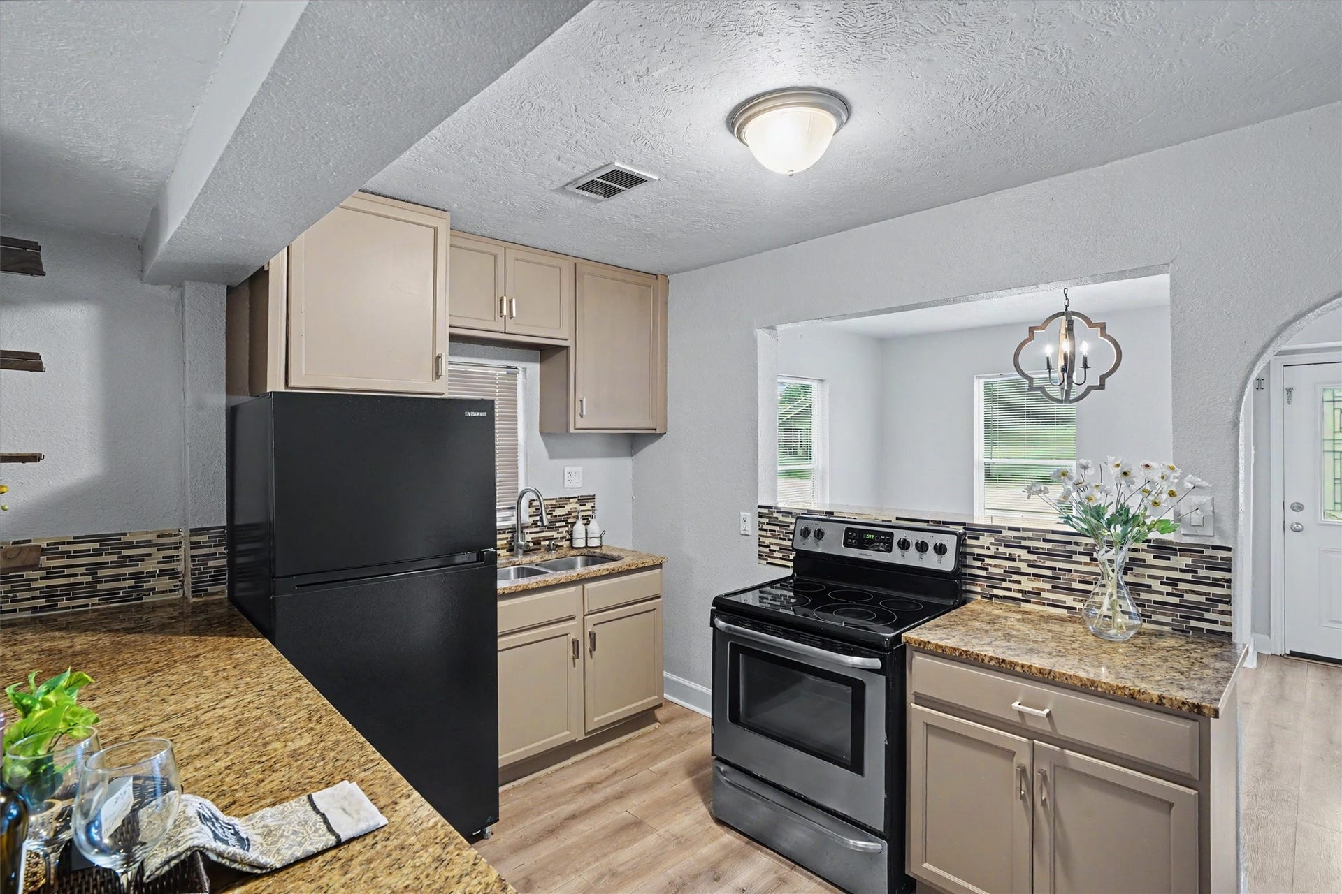 2523 7th Avenue N, Texas City, TX 77590 Kitchen features granite countertops, refinished cabinetry, tile backsplash and a convenient breakfast bar overlooking the adjoining living spaces.