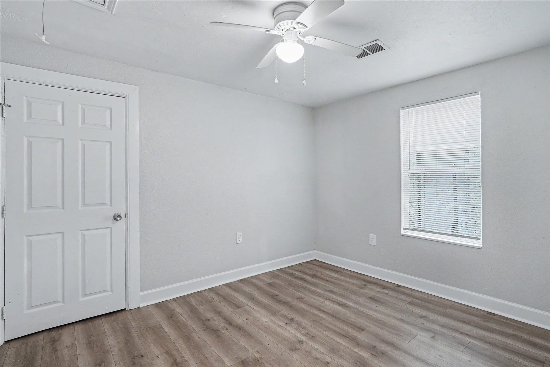 2523 7th Avenue N, Texas City, TX 77590 Secondary bedroom with wood-look flooring, fresh neutral paint, ceiling fan and closet.