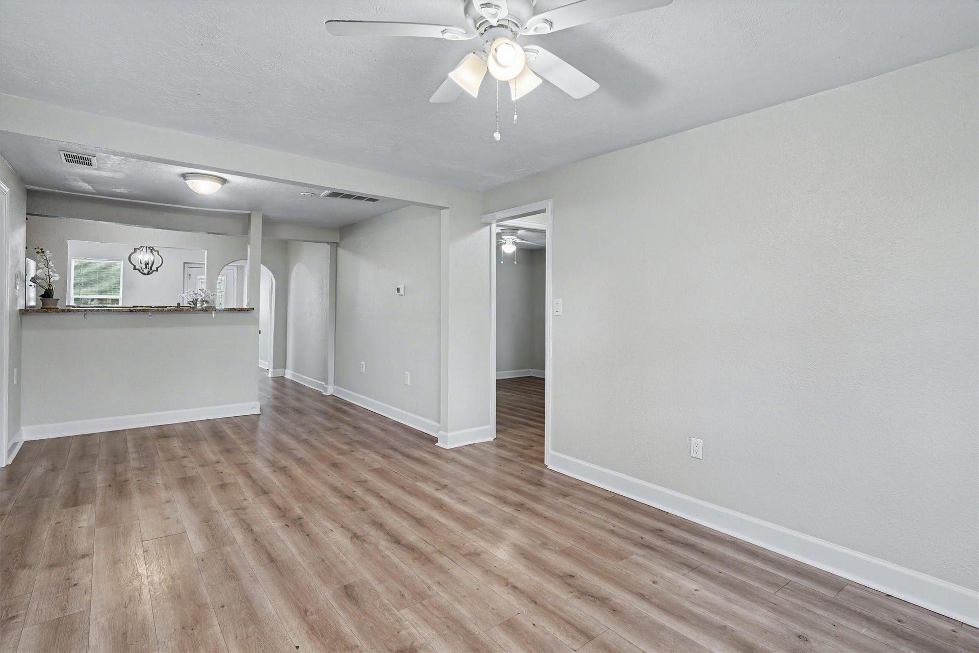 2523 7th Avenue N, Texas City, TX 77590 Spacious living area with wood-look flooring, fresh interior paint and a ceiling fan.