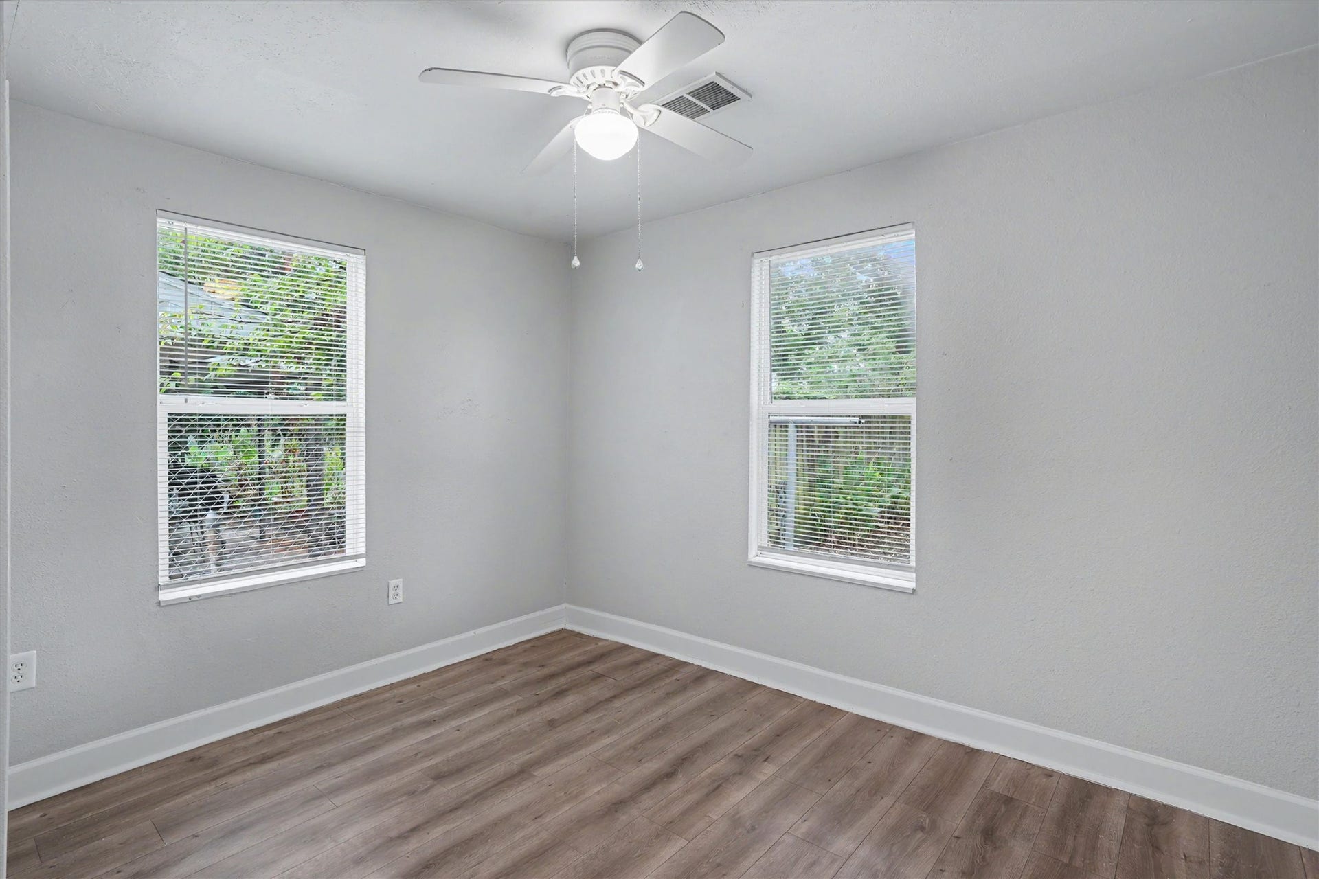 2523 7th Avenue N, Texas City, TX 77590 Bright third bedroom features two windows, ceiling fan and wood-look flooring.