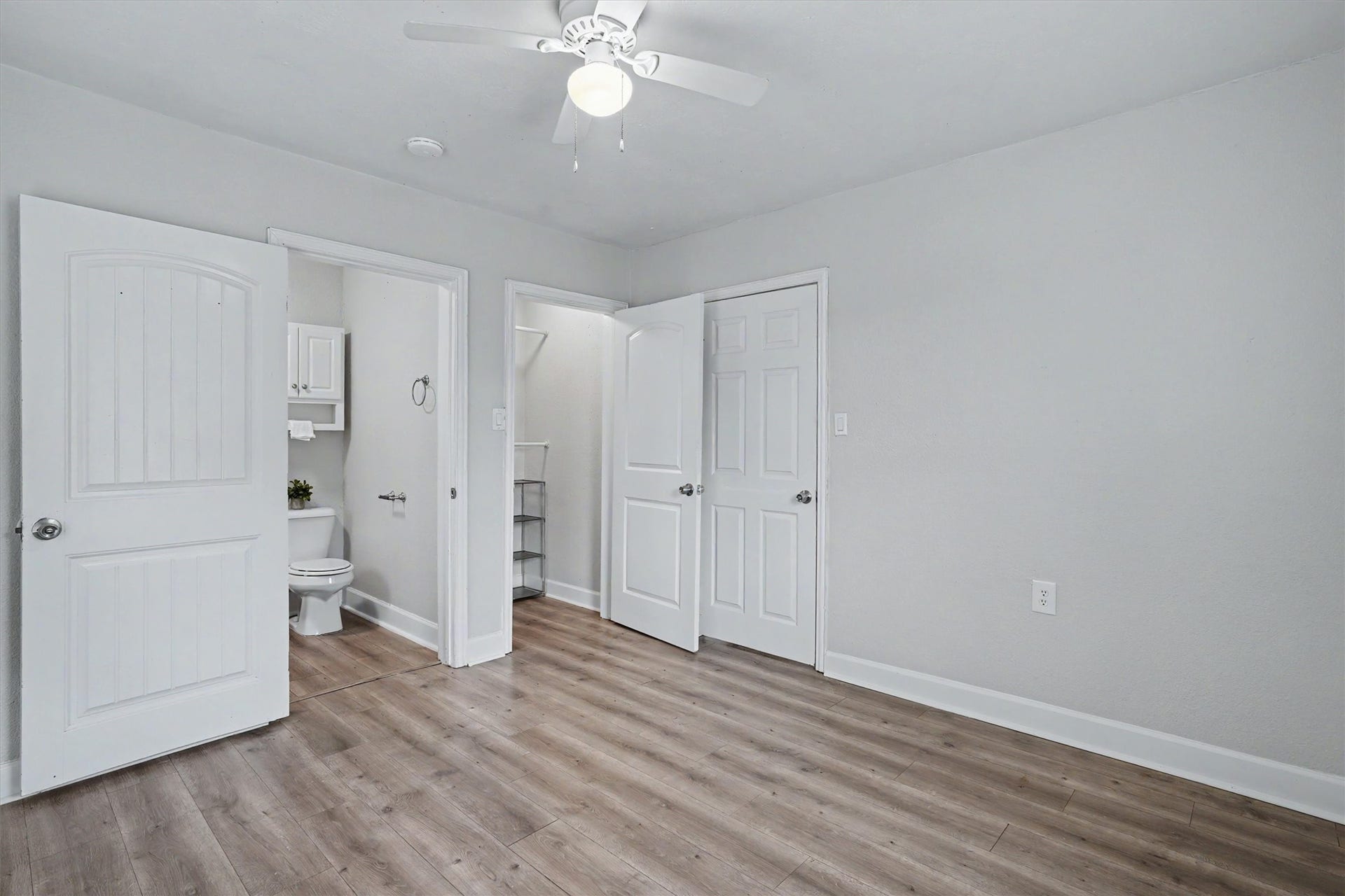 2523 7th Avenue N, Texas City, TX 77590 Primary bedroom features an en-suite bath, closet space, ceiling fan and wood-look flooring.