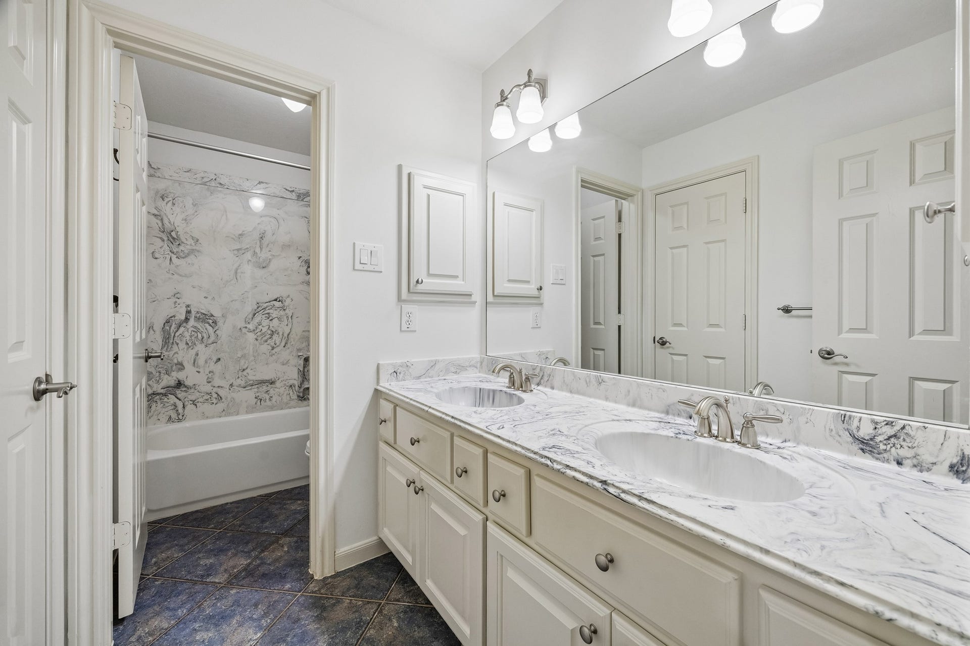 1439 Waverly Street, Houston, TX 77008 En suite bath with dual sinks, generous counter space, abundant cabinetry, and a tub/shower combination, with convenient access from both the bedroom and hallway.