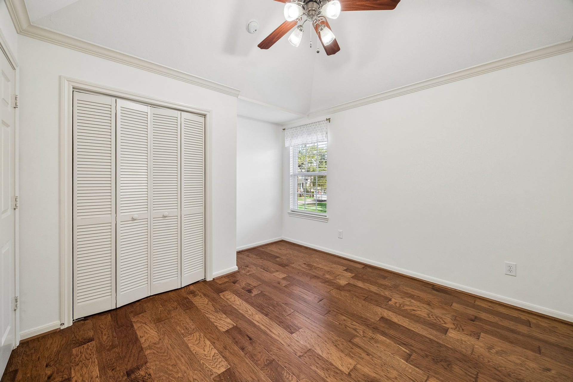 1439 Waverly Street, Houston, TX 77008 Secondary bedroom with hardwood floors, custom window treatments, and an en suite bath.
