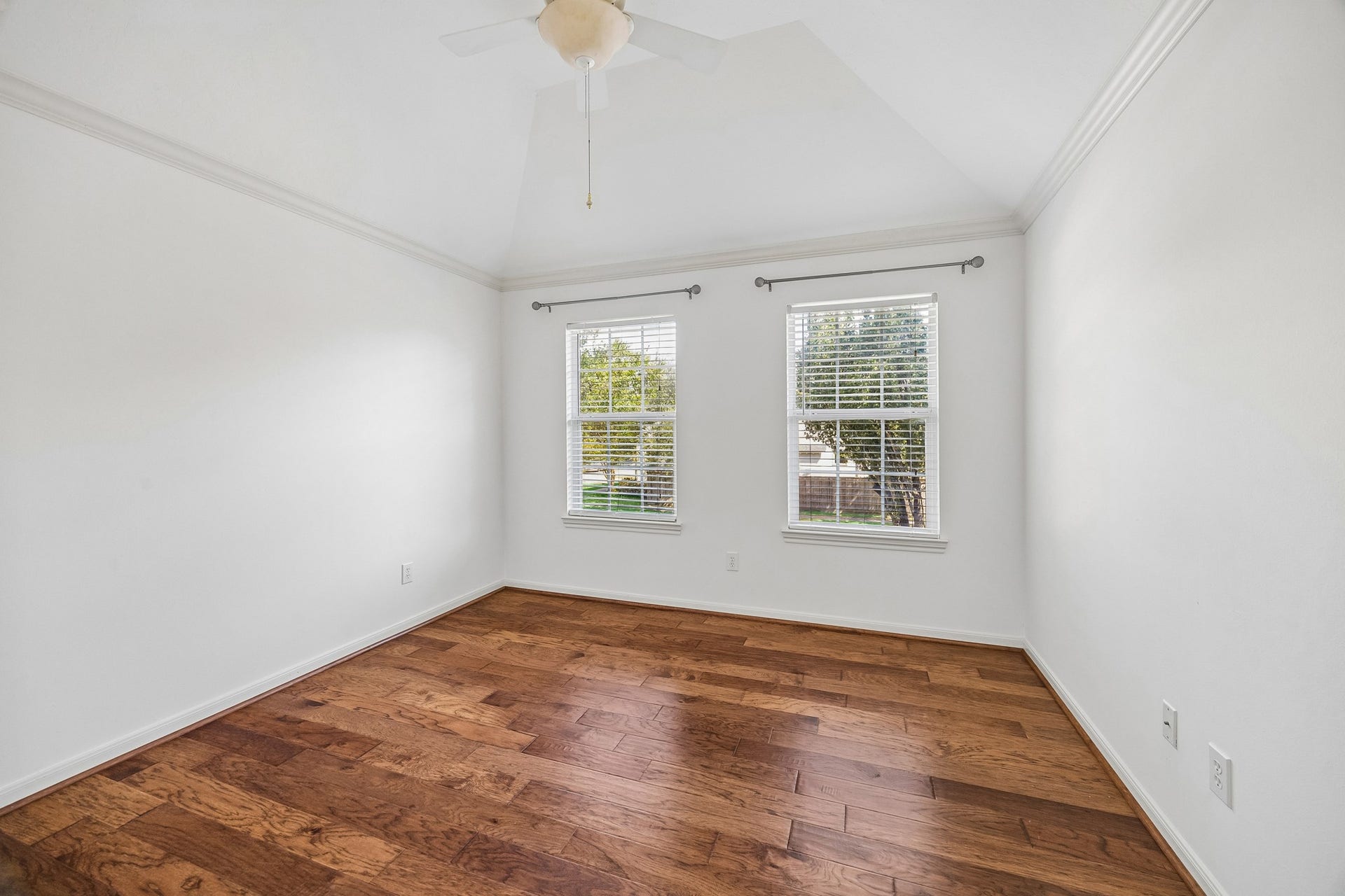 1439 Waverly Street, Houston, TX 77008 Bright secondary bedroom with hardwood floors, a ceiling fan, and two windows overlooking the yard. Space for a freestanding wardrobe offers a flexible closet solution.