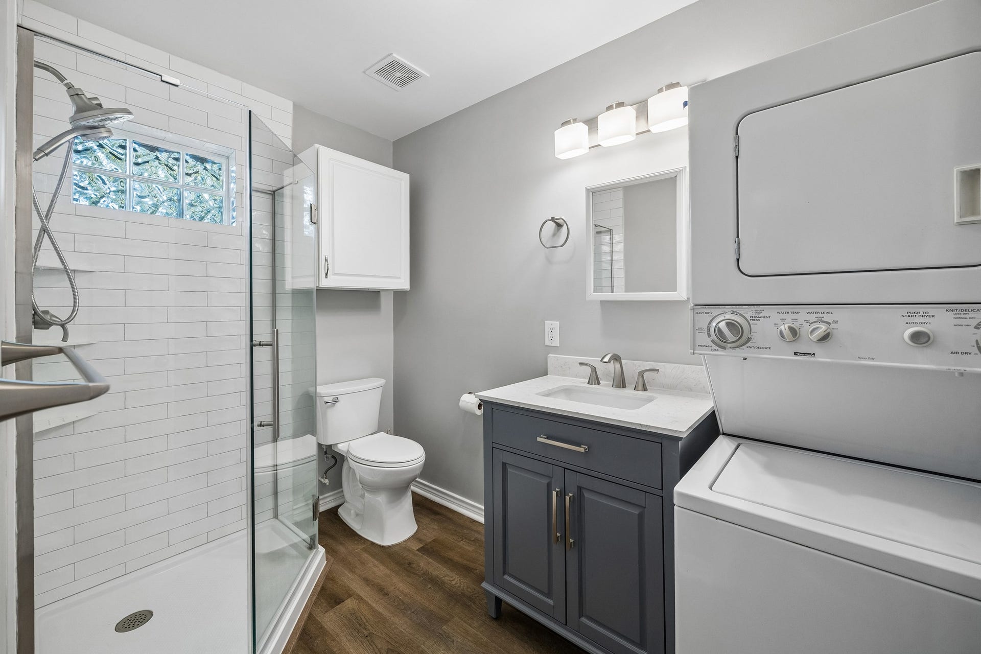 1439 Waverly Street, Houston, TX 77008 Garage apartment bath with a modern vanity, walk-in shower, and included washer and dryer for added convenience.