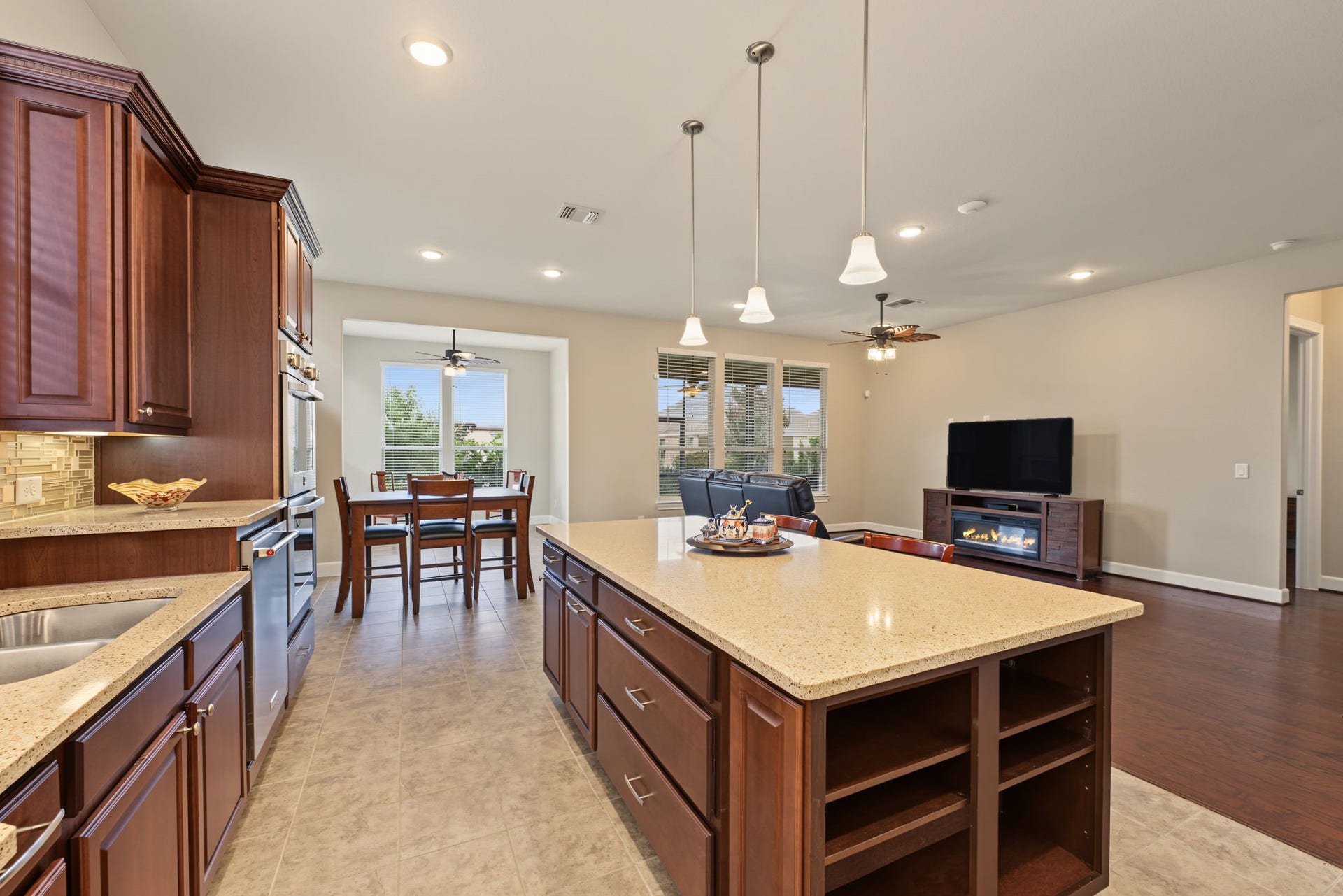 Breakfast area adjacent to the kitchen with a sunroom beyond the breakfast area.