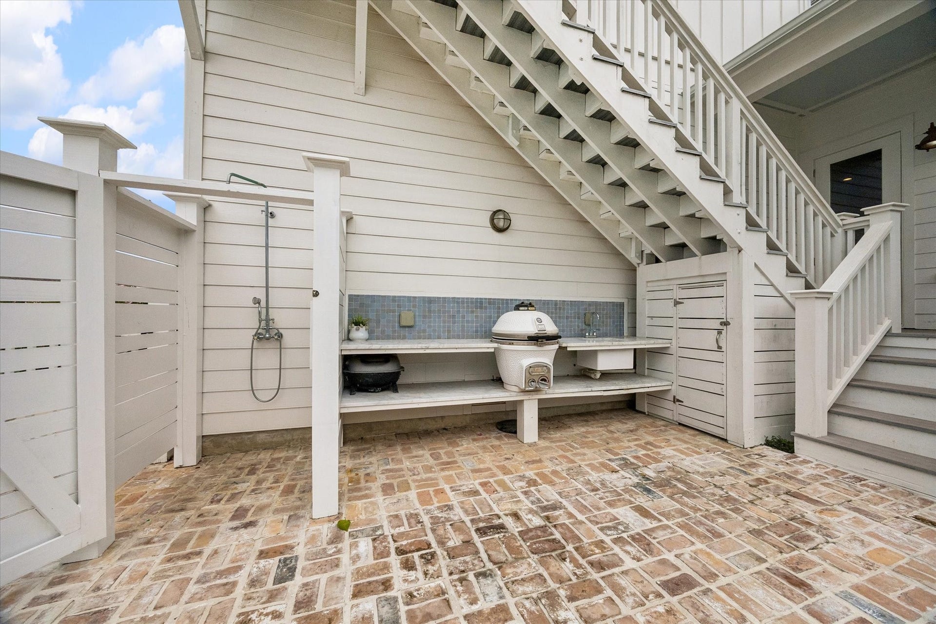 7 Curiosity Lane, Galveston, TX 77554 Outdoor kitchen and shower. Stairs to the 5th bedroom, bunk room or office