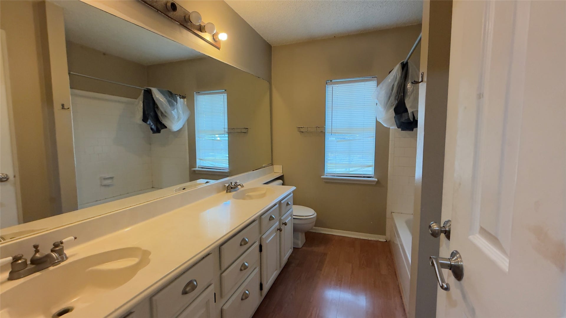 4119 King Cotton Lane, Missouri City, TX 77459 Spacious bathroom featuring a double vanity with ample storage, a large mirror, and natural light from two windows, complemented by a full bathtub and shower.