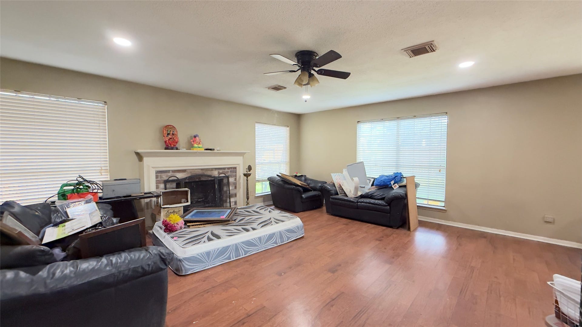 4119 King Cotton Lane, Missouri City, TX 77459 Spacious living room with hardwood floors, a central fireplace, and abundant natural light from large windows.
