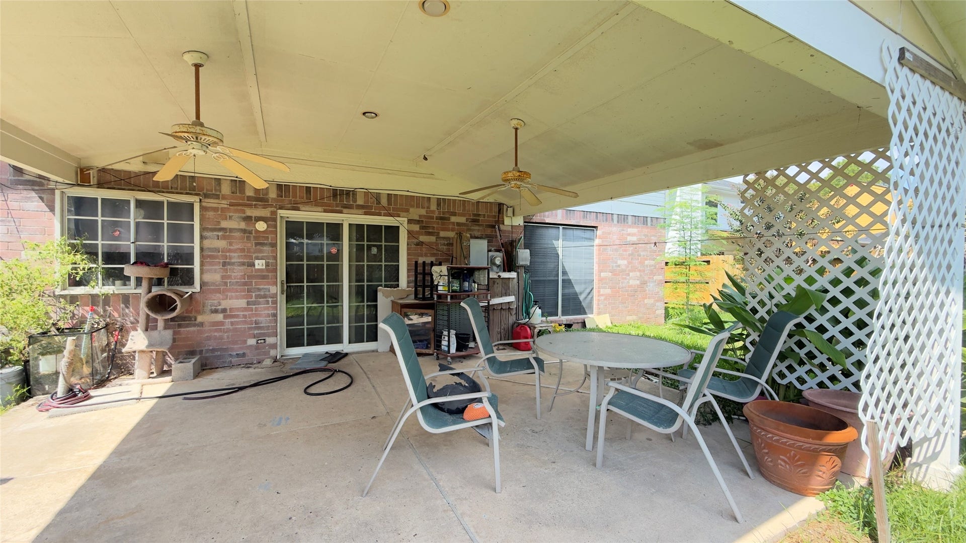 4119 King Cotton Lane, Missouri City, TX 77459 Charming covered patio perfect for outdoor entertaining, featuring ceiling fans and ample seating space surrounded by lush greenery.