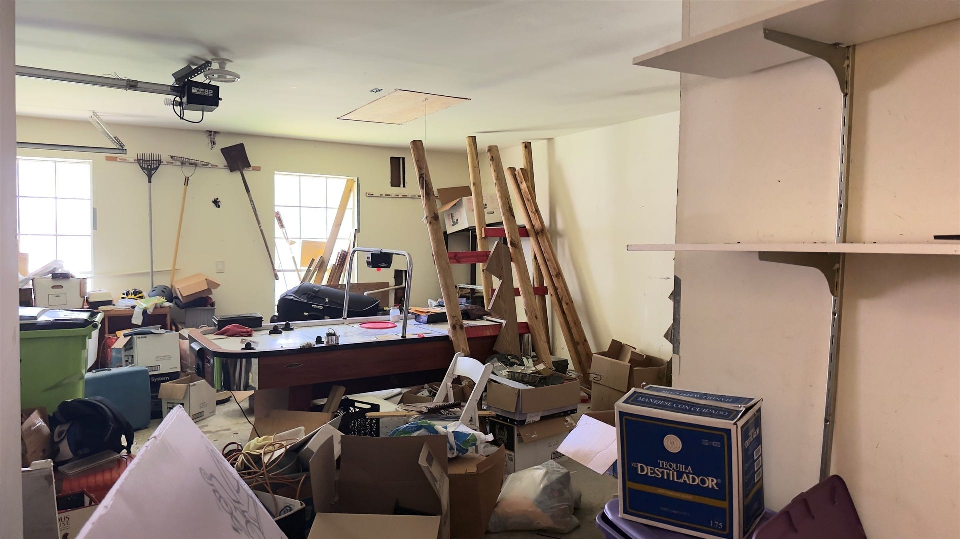 4119 King Cotton Lane, Missouri City, TX 77459 Spacious garage with potential for organization, featuring ample shelving and natural light from large windows. Ideal for storage or a workshop setup.