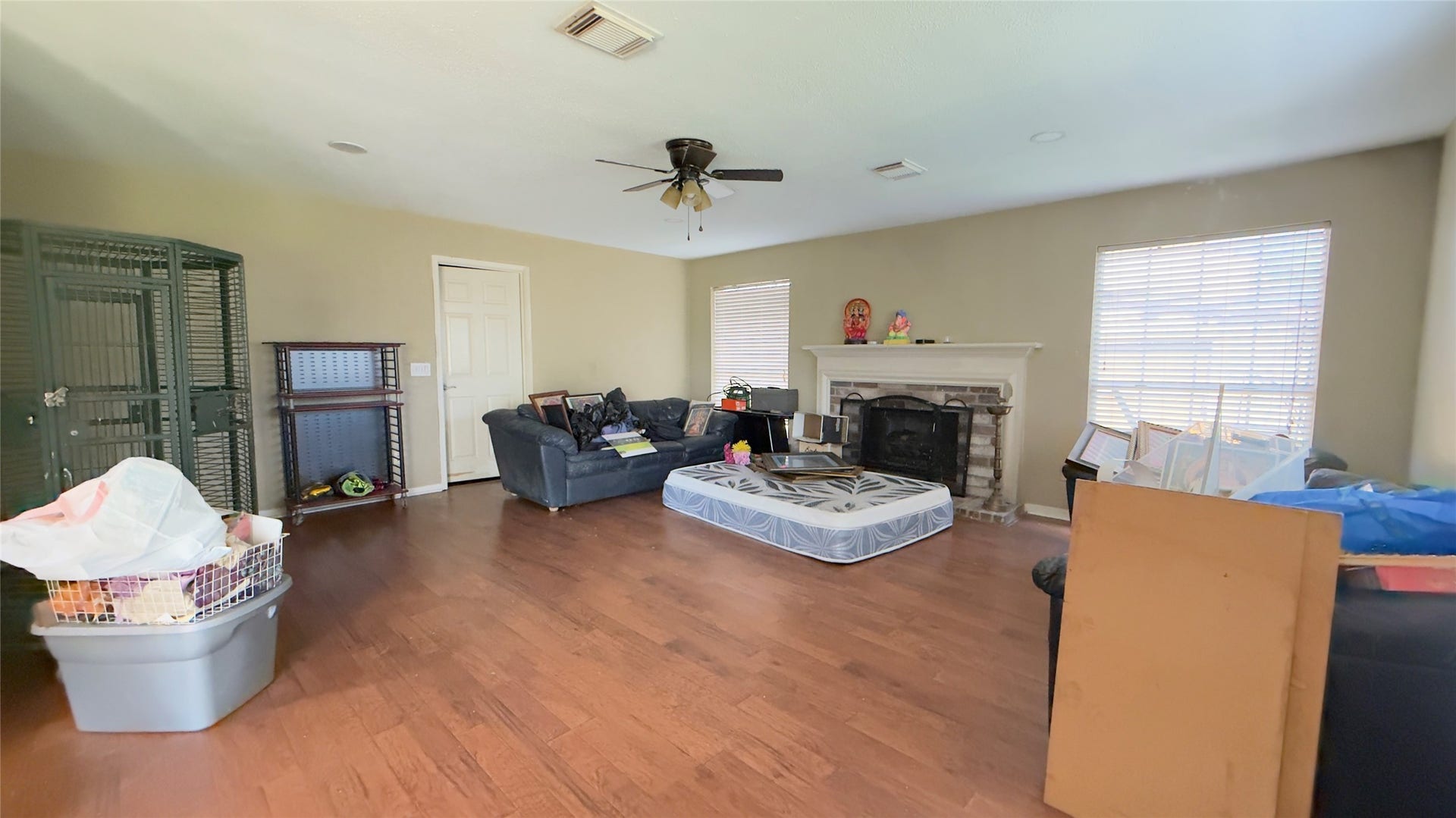 4119 King Cotton Lane, Missouri City, TX 77459 Spacious living room with warm hardwood floors, a cozy fireplace, and abundant natural light from large windows.
