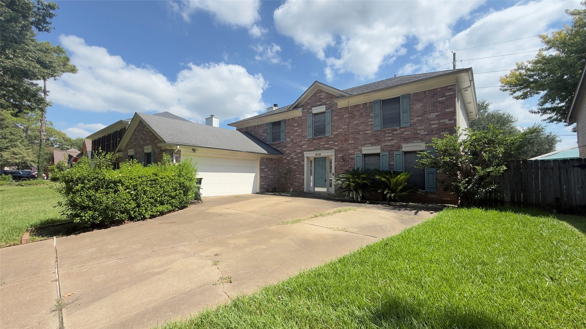 4119 King Cotton Lane, Missouri City, TX 77459 Charming two-story brick home with a spacious driveway, lush greenery, and a large attached garage, set in a serene neighborhood.