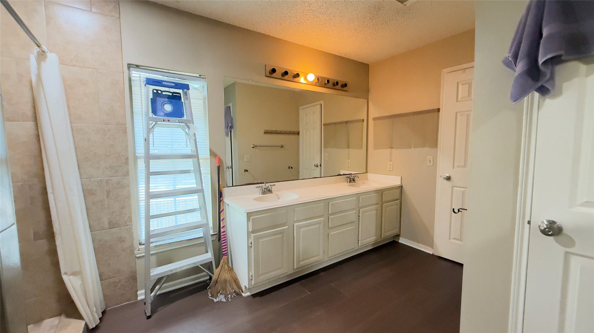 4119 King Cotton Lane, Missouri City, TX 77459 Spacious master bathroom featuring a large vanity with dual sinks, a sizable mirror, and a tiled shower area, complemented by natural light from the window.