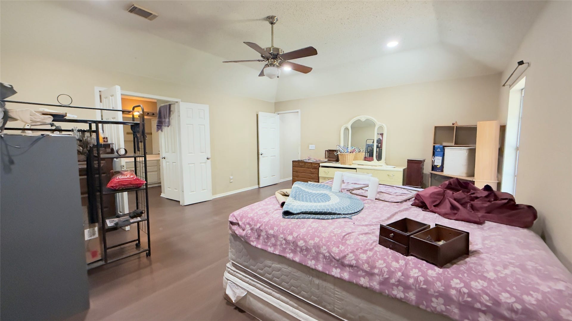 4119 King Cotton Lane, Missouri City, TX 77459 Spacious master bedroom featuring a vaulted ceiling with a ceiling fan, ample storage options, and an ensuite bathroom access.