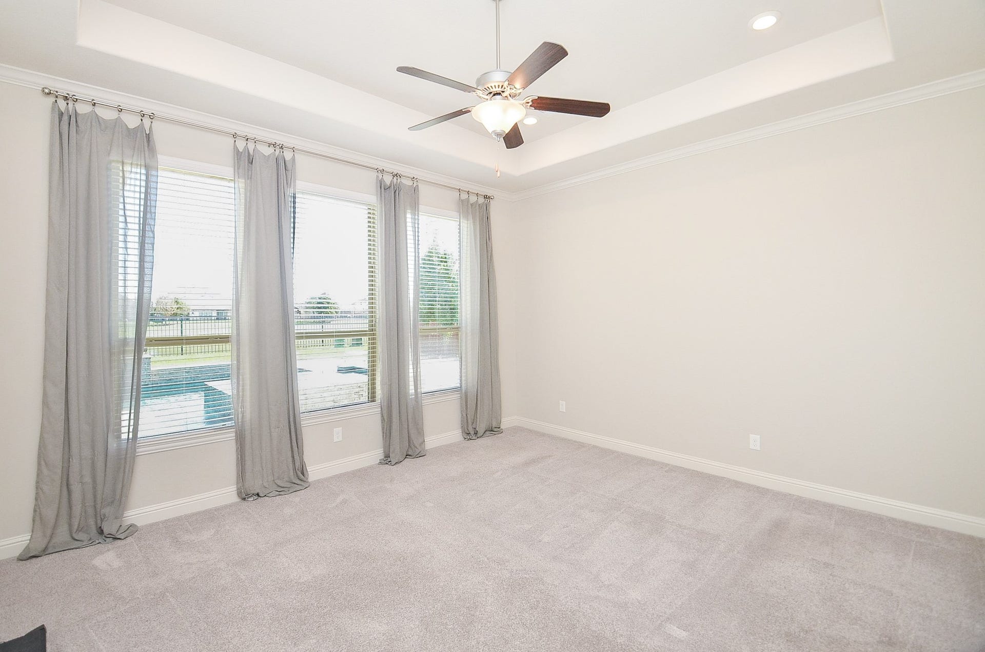 18438 Panton Terrace Lane, Cypress, TX 77429 Master bedroom featuring large windows with views of the pool and lake!