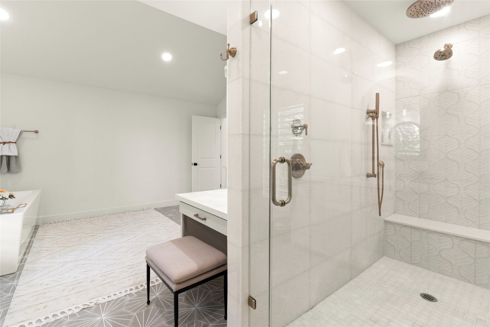 14 Lush Meadow Place, The Woodlands, TX 77381 Glass-enclosed shower with decorative tilework, rainfall showerhead, and built-in bench.